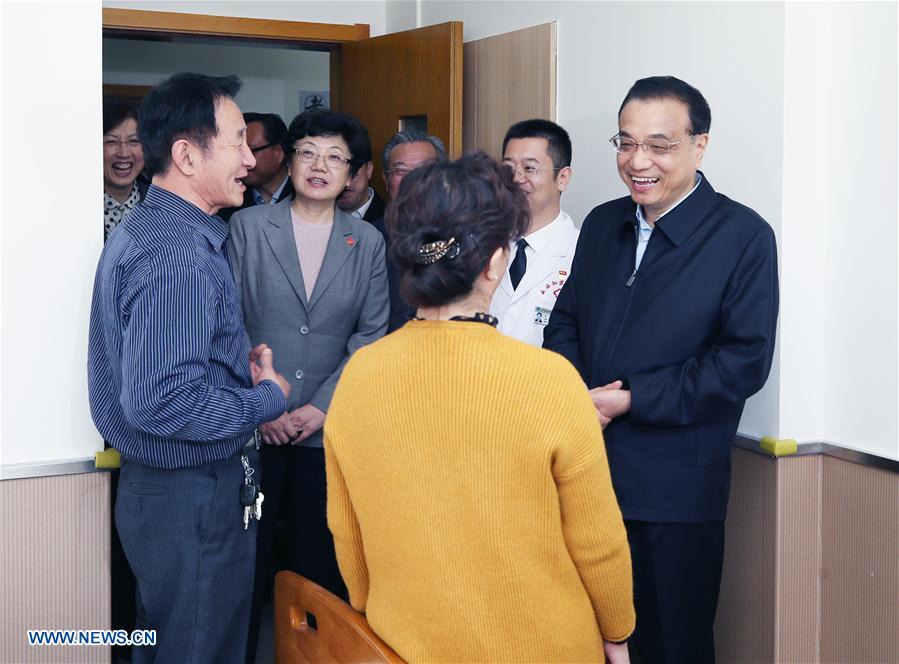 Chinese Premier Li Keqiang (1st R) visits senior people at a hospital in Weihai City, east China