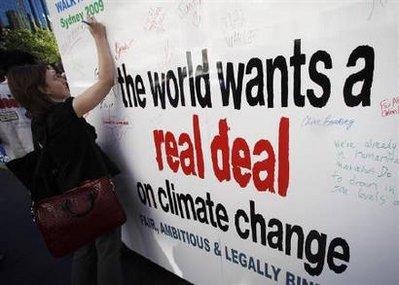 A woman signs a placard asking for a deal in the Copenhagen climate meeting, in central Sydney December 11, 2009. REUTERS/Daniel Munoz 