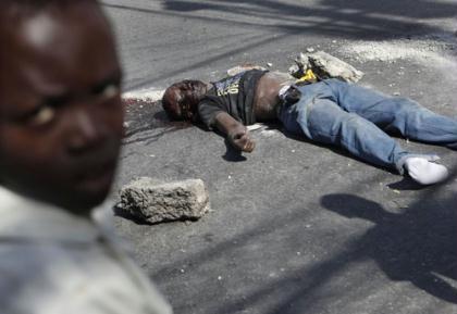 The body of a young man lies in the street after he was stoned to death by residents who accused him of stealing in Port-au-Prince January 22, 2010. Cash became available and buses started running in Haiti's wrecked capital but earthquake survivors are still desperate for food and aid. (Xinhua/Reuters Photo)