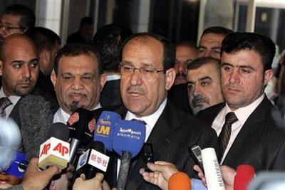 Iraqi Prime Minister Nouri al-Maliki, center, speaks to reporters after voting in Iraqi parliamentary elections at a polling station in the Green Zone in Baghdad, Iraq Sunday March 7, 2010. (AP Photo/Ali Abbas, Pool)