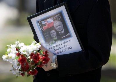 A mourner carries a tribute to the Polish President Lech Kaczynski upon arriving at a ceremony at the Katyn memorial in Toronto on Sunday, April 11, 2010. The ceremony, initially organized to mark the 70th anniversary of the Katyn massacre, was dominated by remembrance for the Polish President Lech Kaczynski who died alongside 95 other passengers after their plane crashed in Smolensk, Russia on Saturday. (AP Photo/The Canadian Press, Chris Young) 