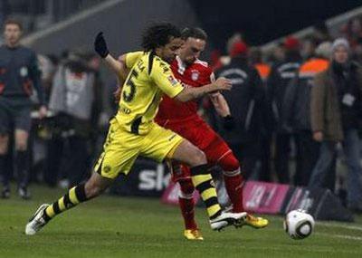 Bayern Munich's Franck Ribery (R) is tackled by Borussia Dortmund's Patrick Owomoyela during their German Bundesliga soccer match in Munich February 13, 2010. REUTERS/Michaela Rehle