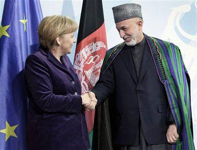 German Chancellor Angela Merkel, left, and the President of Afghanistan, Hamid Karzai, right, shake hands after a news conference as part of a meeting at the chancellery in Berlin, Germany, Wednesday, Jan. 27, 2010. (AP Photo/Michael Sohn)