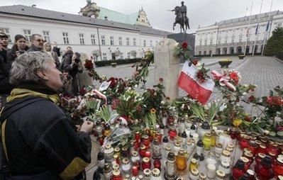 A mourner holds a prayer in front of the Presidential Palace in Warsaw, Poland, Saturday, April 10, 2010, as news broke out about Polish President's Lech Kaczynski death. Polish President Lech Kaczynski and his wife died Saturday along with 130 others when their plane crashed while coming in for a landing in western Russia.(AP Photo/Czarek Sokolowski) 