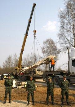 Emergency ministry workers load the wreckage of the Polish presidential plane on transporter just outside the Smolensk airport, western Russia, Wednesday, April 14, 2010 as police secure the scene. Polish President Lech Kaczynski, his wife and some of the country's most prominent military and civilian leaders died Saturday along with dozens of others when the presidential plane crashed as it came in for a landing in thick fog near Smolensk in western Russia.(AP Photo/Mikhail Metzel)