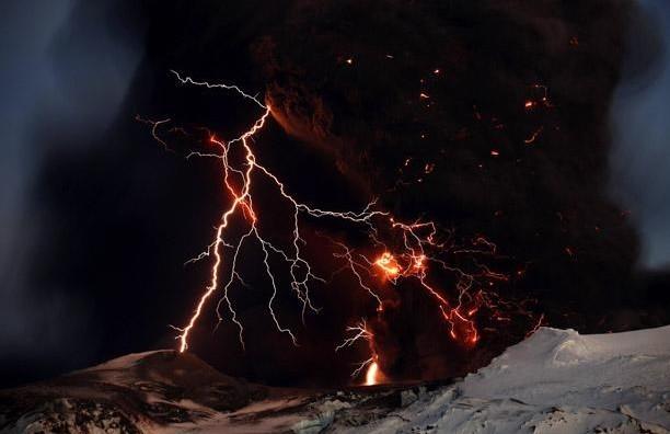 Lightning streaks across the sky as lava flows from a volcano in Eyjafjallajokul