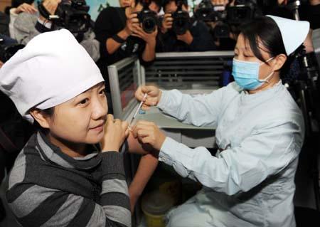 Sun Yan (L), a doctor of Zhengzhou No.6 People's Hospital, receives the A/H1N1 influenza vaccination in Zhengzhou, capital of central China's Henan Province, Oct. 31, 2009. A vaccination program against the A/H1N1 virus is kicked off in the province on Saturday. (Xinhua/Zhao Peng)