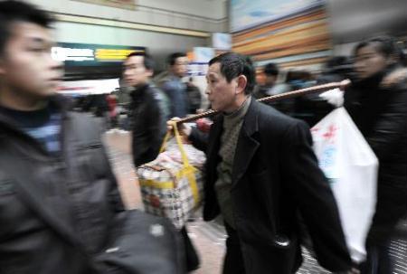 A migrant worker rushes to catch his train at Beijing West Railway Station in Beijing, China, Jan. 20, 2010. The railway peak transport in Spring Festival season in Beijing started on Wednesday. Millions of Chinese will rush back home for the Spring Festival, China's Lunar New Year, which falls on Feb. 14 this year.(Xinhua/Jin Liangkuai)