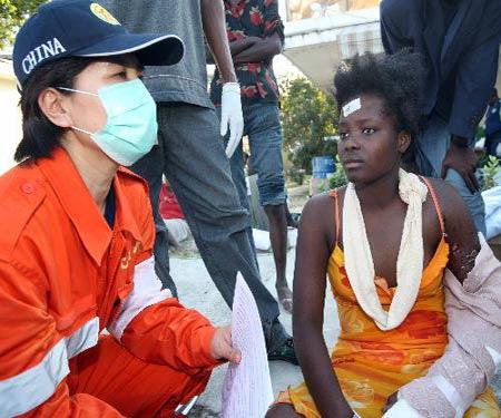 Cao Li (L), a member of China International Search and Rescue Team, gives psychotherapy to a young Haitian woman in Port-au-Prince Jan. 20, 2010. Members of China International Search and Rescue Team came to a local medical center on Wednesday to offer medical help and psychological consultations to people injured at the Jan. 12 earthquake. (Xinhua/Yuan Man)