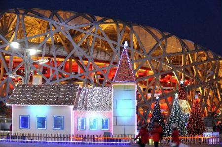 People walk past decorative landscapes in front of the National Stadium, also known as the "Bird's Nest", in Beijing, capital of China, Feb. 12, 2010. (Xinhua/Wang Huaigui)