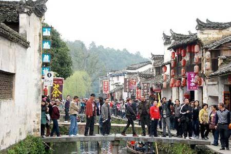 Tourists pour into the scenic residential district for sightseeing at Likeng village in Wuyuan county, south China's Jiangxi province, March 21, 2010. The scenic beauty of gardens in countrysides and local styles of residential houses attracted a great number of Chinese and foreign tourists to come. [Xinhua photo]