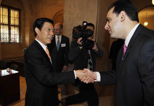 Chinese Vice Commerce Minister Zhong Shan is greeted by an unidentified person while attending the breakfast meeting at the U.S. Chamber of Commerce in Washington, D.C., capital of the United States, March 24, 2010. (Xinhua/Zhang Jun)