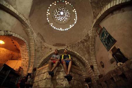 Palestinian boys sit at Hamam al-Samra, a traditional Turkish steam bath in Gaza City, on April 10, 2010. The hamam is one of the ancient archaeological places in the Gaza Strip built in 1,000 years ago. (Xinhua/Wissam Nassar)