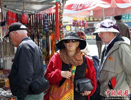 Photo shows foreign tourists shopping in the Barkhor Street, downtown Lhasa. Tibet is ready to meet its tourist boom and is expected to receive six million tourists in 2010.[Photo Source: chinanews.com) 