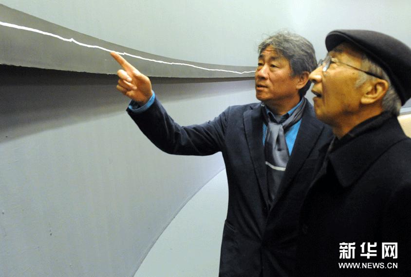 12月7日，譚平（左）在介紹自己的抽象版畫作品《＋40m》的創作過程。