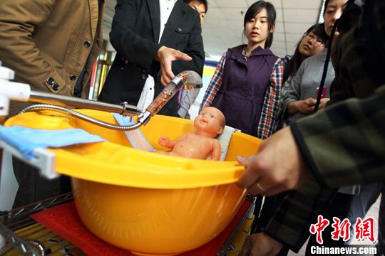 設計者在演示“自動循環淋水的嬰兒澡盆”。泱波 攝