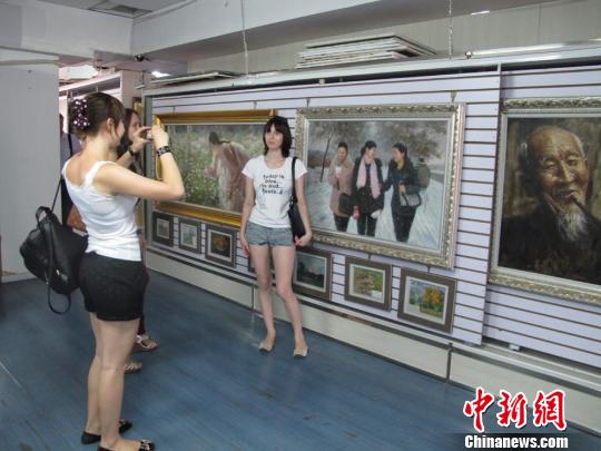 俄羅斯參觀者在朝鮮畫前合影留念　楊靜　攝