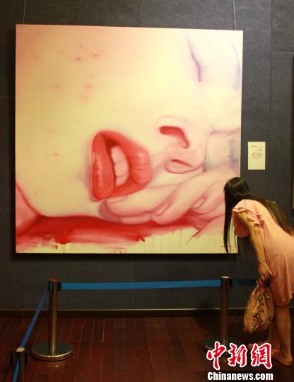 圖為觀眾在欣賞魯迅美術學院教授張志堅的油畫作品《作品37號》。　司曉帥　攝