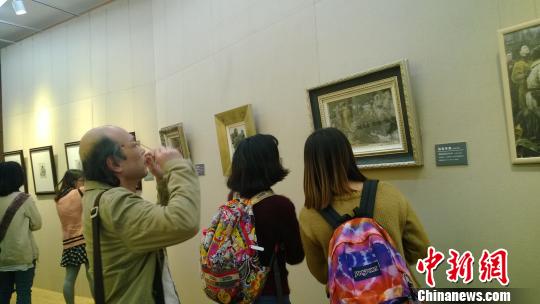 參觀者在欣賞畫作。　張駿　攝