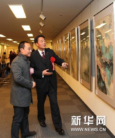 1月20日，在日本東京，日本眾議院議員、民主黨黨首海江田萬里（右）在畫展上欣賞作品。新華網圖片 馮武勇 攝