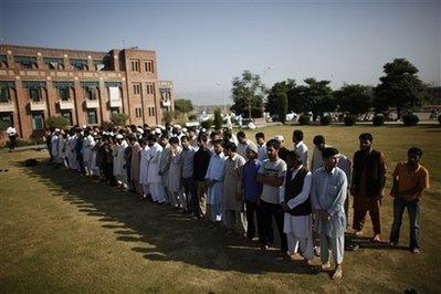 Students prepare for funeral prayers for the victims of Tuesday's twin suicide bombings at the International Islamic University in Islamabad, Pakistan, Wednesday, Oct. 21, 2009. Educational institutions were shuttered in Pakistan on Wednesday after suspected militants bombed the university close to the capital, sowing fear across the country as the army presses on with a major anti-Taliban offensive.(AP Photo/Alexandre Meneghini)