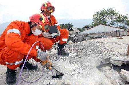 Members of China International Search and Rescue Team (CISAR) search for survivors on debris near a destroyed supermarket in Port-au-Prince, Haiti, Jan. 19, 2010. The CISAR continued the rescue mission Tuesday in the city. (Xinhua/Yuan Man)