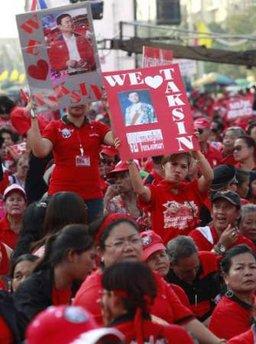 Demonstrators hold a portrait of exiled former premier Thaksin Shinawatra during a rally at the Democracy Monument in Bangkok December 10, 2009. Thousands of red-shirted protesters gathered to press their demands for fresh elections. REUTERS/Chaiwat Subprasom