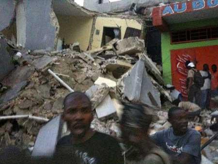 Scared people stand nearby a collapsed building after the 7.0 magnitude earthquake in Port-Au-Prince of Haiti, Tuesday, Jan. 12, 2010.(Xinhua/AFP Photo)