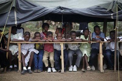 Children wait for the inauguration of a school that will be run by an Israeli NGO at a camp for earthquake survivors in Port-au-Prince, Friday, March 5, 2010. (AP Photo/Esteban Felix)