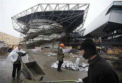 Workers carry construction materials in front of the German Pavilion under construction at the Shanghai World Expo site Monday, March 8, 2010 in Shanghai. Less than two months before the Shanghai World Expo opens, organizers said Monday that preparations for taking the wrapping off the pavilions and putting crowd control measures in place for the expected 70 million visitors are on track. (AP Photo/Eugene Hoshiko) 