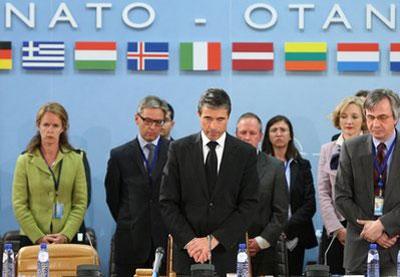 NATO Secretary General Anders Fogh Rasmussen, center, leads a minute of silence at NATO headquarter in Brussels, Monday April 12, 2010. (AP Photo/Yves Logghe)