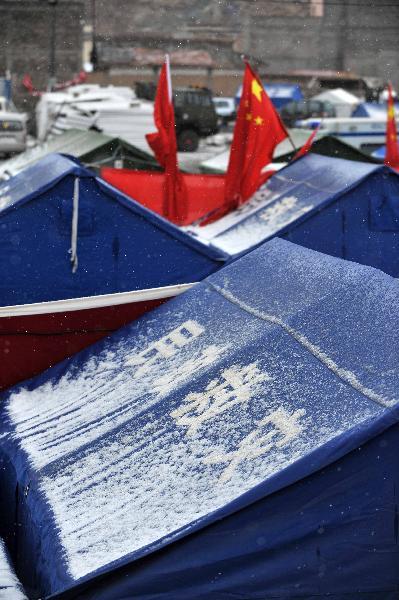 Snow sleet are seen on several makeshift tents in Yushu County, northwest China Qinghai Province, April 20, 2010. The quake-hit area was hit by snow and rainfall on Tuesday. (Xinhua/Hou Deqiang)