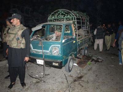 Police guard beside a destroyed car in Charsadda, a city some 30 kilometers north of Peshawar of Pakistan, Nov. 10, 2009. A suicide car bomb attack killed at least 20 people in a crowded market place in Charsadda on Tuesday.(Xinhua/Umar Qayyum)