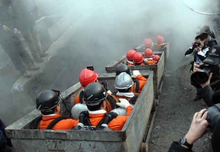 Rescuers get ready to go down into the pit to search for survivors at the site of the accident at the Xinxing Coal Mine in Hegang City, northeast China's Heilongjiang Province, on Nov. 22, 2009. The underground ventilation system has been restored and 90% of the underground working face has been searched. A total of 87 bodies of miners were found as of 12 a.m. Sunday, and another 21 are still trapped in the shaft, said local authorities. (Xinhua/Wang Song)