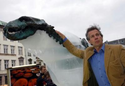 British explorer Pen Hadow touches an ice sculpture of a polar bear as it melts to reveal a bronze skeleton in Copenhagen Dec. 8, 2009. The ice sculpture had been placed in downtown Copenhagen since Dec. 5, 2009, to draw the attention of people about the rising temperature. (Xinhua/Zhang Yuwei)