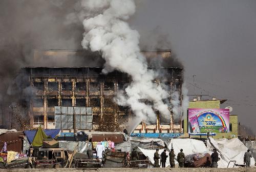 Afghan policemen stand in front of the shopping mall, where Taliban gunmen battled security forces for hours, as the government forces restored control after the attack in Kabul January 18, 2010.(Xinhua/Reuters Photo)