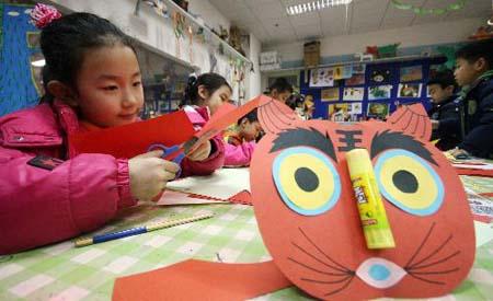 Children make paper-cut works on an exhibition of paper-cuts by students for the upcoming Lunar New Year of the Tiger in north China's Tianjin Municipality, Feb. 8, 2010. (Xinhua/Liu Dongyue)