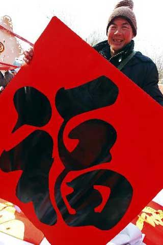 A citizen shows a well-wishing decoration with Chinese character 