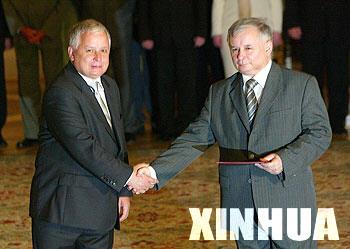 File photo shows Polish President Lech Kaczynski (L) shakes hands with his twin brother Jaroslaw Kaczynski after nominating him as the new Polish prime minister in the presidential palace in Warsaw, July 10, 2006.(Xinhua File Photo)