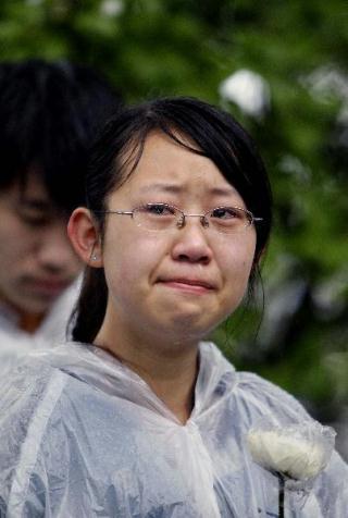 A student of Fudan University weeps for the victims of Yushu earthquake during a mourning ceremony in Shanghai, east China, April 21, 2010. (Xinhua/Liu Ying)