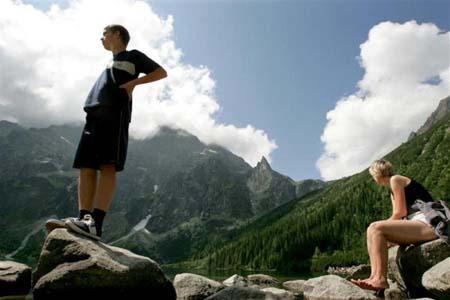 Tourists rest by Lake Morskie Oko and admire the view of the high Tatra Mountains in southern Poland August 5, 2004.[Agencies] 