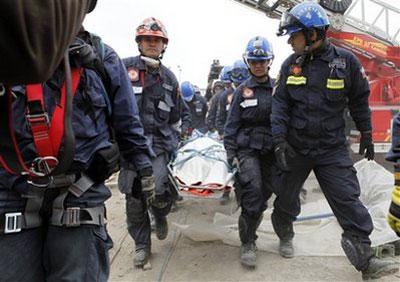 Rescue crews remove a dead body from a destroyed building in Concepcion, Chile, Monday, March. 1, 2010. An 8.8-magnitude earthquake struck central Chile early Saturday. (AP Photo/ Aliosha Marquez)