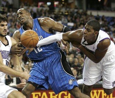 Orlando Magic center Dwight Howard battles for the ball with Sacramento Kings' Omri Casspi, left, of Israel, and Jason Thompson, during the first quarter of an NBA basketball game in Sacramento, Calif., Tuesday, Jan. 12, 2010.(AP Photo/Rich Pedroncelli)