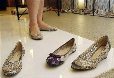 In this photo taken Thursday, Nov. 19, 2009, Taiwanese fashion designer Colin Lin displaying shoes made out of recycled newspapers. Lin's environmentally friendly footwear company produces shoes and tote bags for green-minded consumers around the world.(AP Photo/Chiang Ying-ying) 