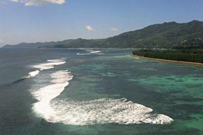 Waves break over coral reef near the coast of the Seychelles main island Mahe. For the Seychellois and other people living on low-lying islands, climate change is a tangible issue that literally knocks on their front door every morning and poses a very existential question.(AFP/File/Roberto Schmidt)