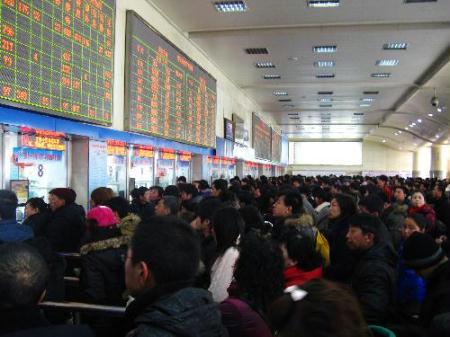 People queue up to buy tickets at a railway station in Shenyang, capital of northeast China's Liaoning Province, on Feb. 18, 2010. Coach and railway terminals in major Chinese cities are bracing for a fresh travel rush, as millions of festival travelers set foot on return trips to city work after the week-long Spring Festival holiday. (Xinhua/Jiang Tieying) 