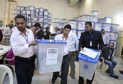 Electoral workers carry ballot boxes at a counting center in Baghdad, Iraq, Tuesday, March 9, 2010. (AP Photo/Karim Kadim)