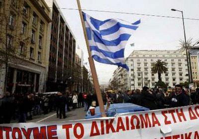 Former employees of privatized Olympic Airways stand behind barricades in front of Greece's General Accountants office in Athens March 10, 2010. REUTERS/Yiorgos Karahalis