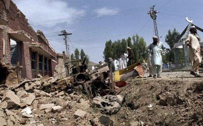 Local residents survey the damages of a police station after a suicide bombing in Kohat, Pakistan on Sunday, April 18, 2010. (AP Photo)