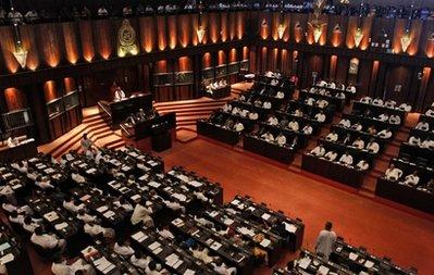 Speaker of the Sri Lankan Parliament and President Mahinda Rajapaksa's elder brother Chamal Rajapaksa presides over the house as ruling party members, background, and opposition party members, foreground, sit during the commencement of Parliament in Colombo, Sri Lanka, Thursday, April 22, 2010. Sri Lanka's former army chief Sarath Fonseka on Thursday used his first opportunity to address Parliament as a newly elected lawmaker to demand his release from detention.(AP Photo/Eranga Jayawardena)